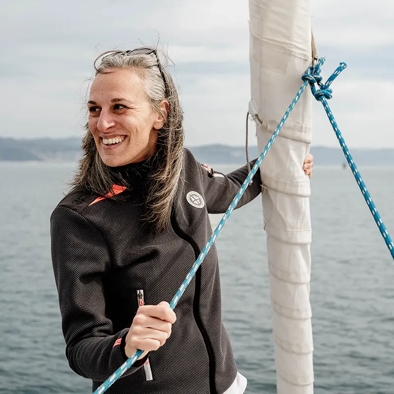 Ilaria Massocco a bordo di una barca a vela, con una cima in mano accanto all'albero
